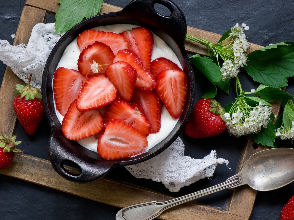Свежая клубника с йогуртом на завтрак на столе с белым цветком