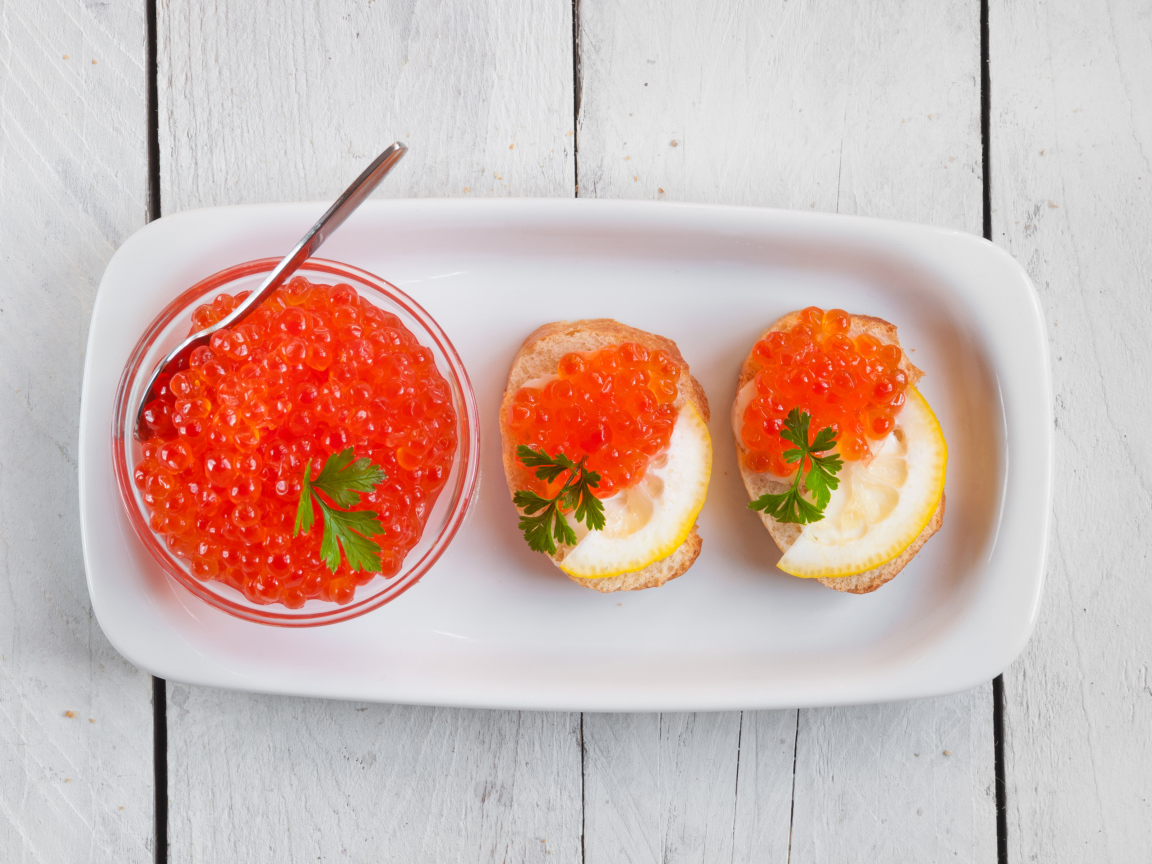 Sandwiches with red caviar and lemons