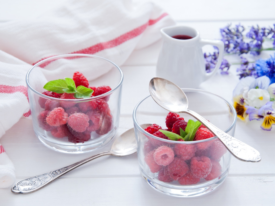 Малина в прозрачный стаканах на завтрак на столе