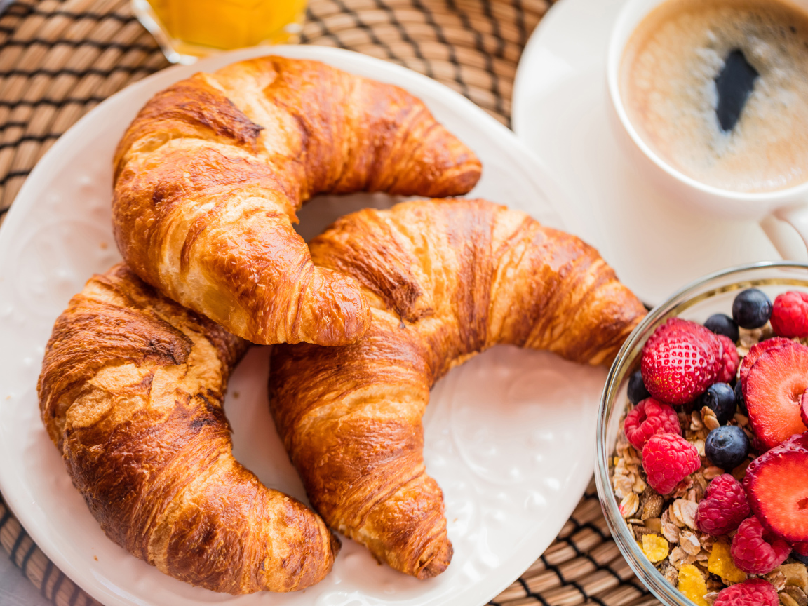 Три свежих круассана и мюсли с ягодами на завтрак