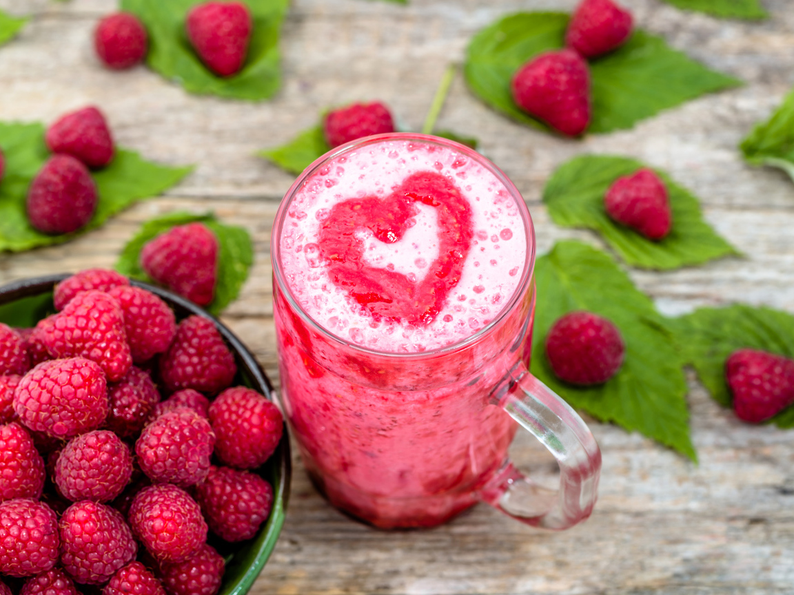 Бокал малинового коктейля со свежими ягодами малины