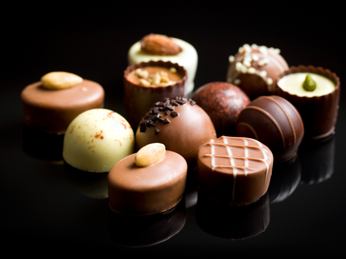 Аппетитные шоколадные конфеты на черном фоне