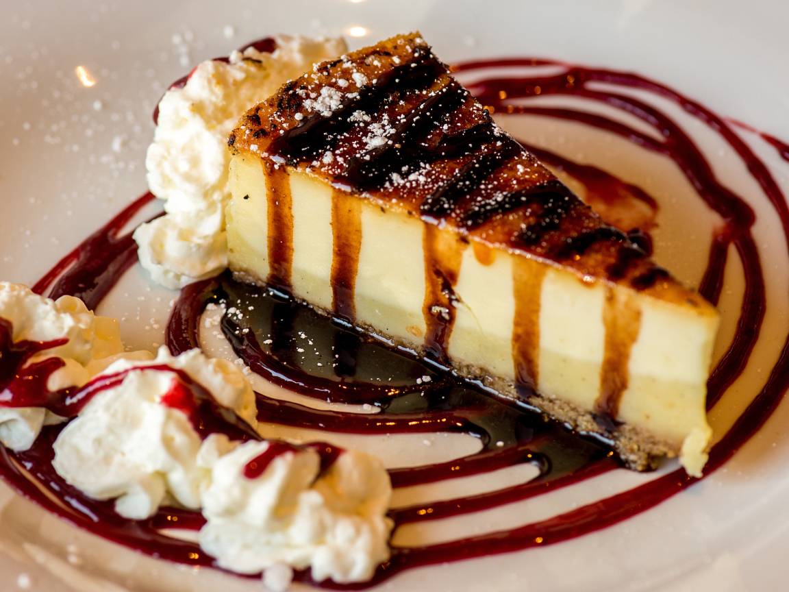 Аппетитный кусок чизкейка со сливками и клубничным джемом