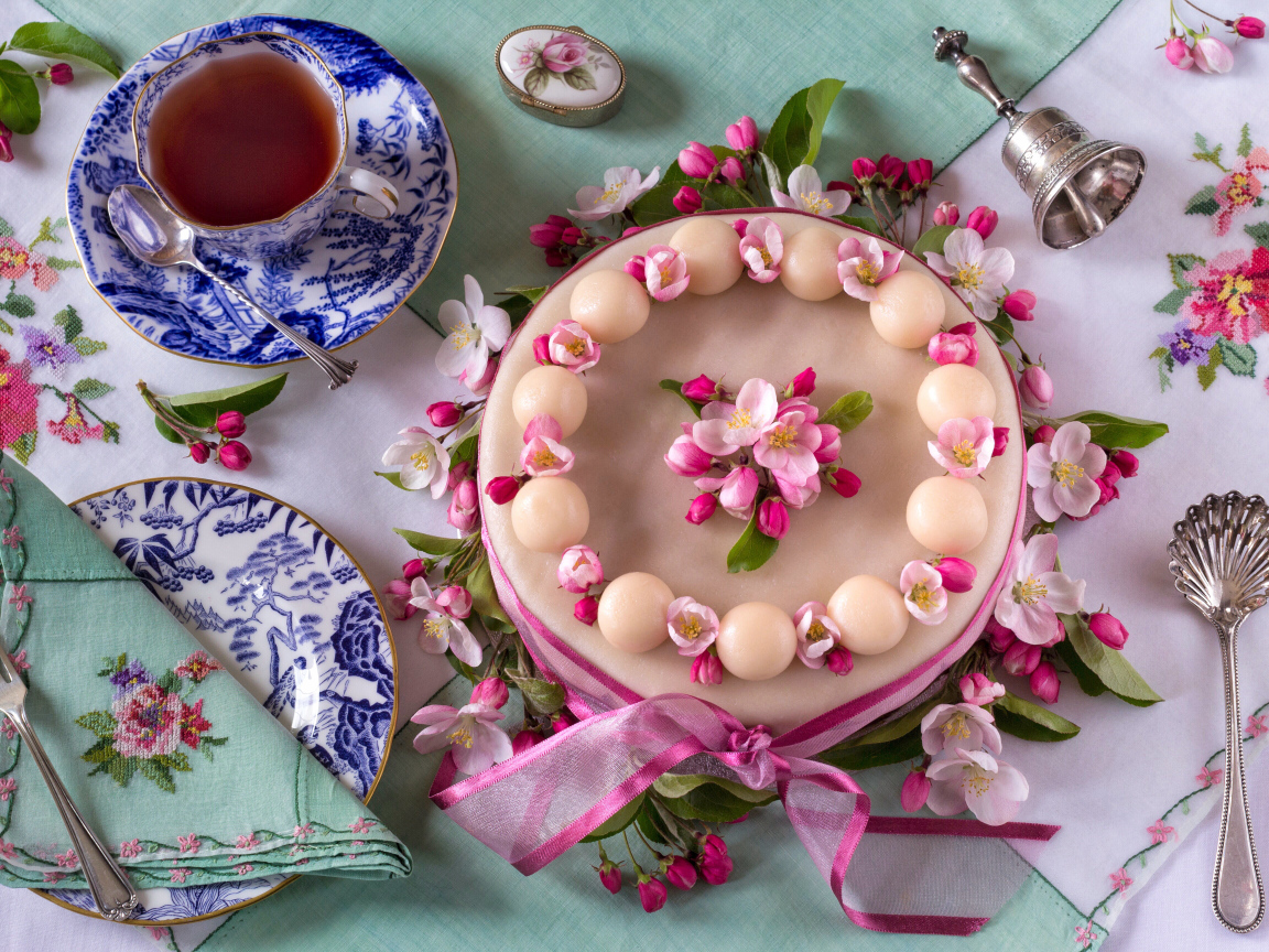 Торт с розовыми цветами на столе с красивым сервизом 
