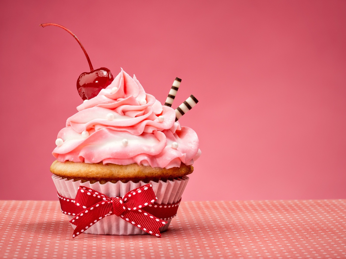 Капкейк с кремом и вишней красиво украшен лентой