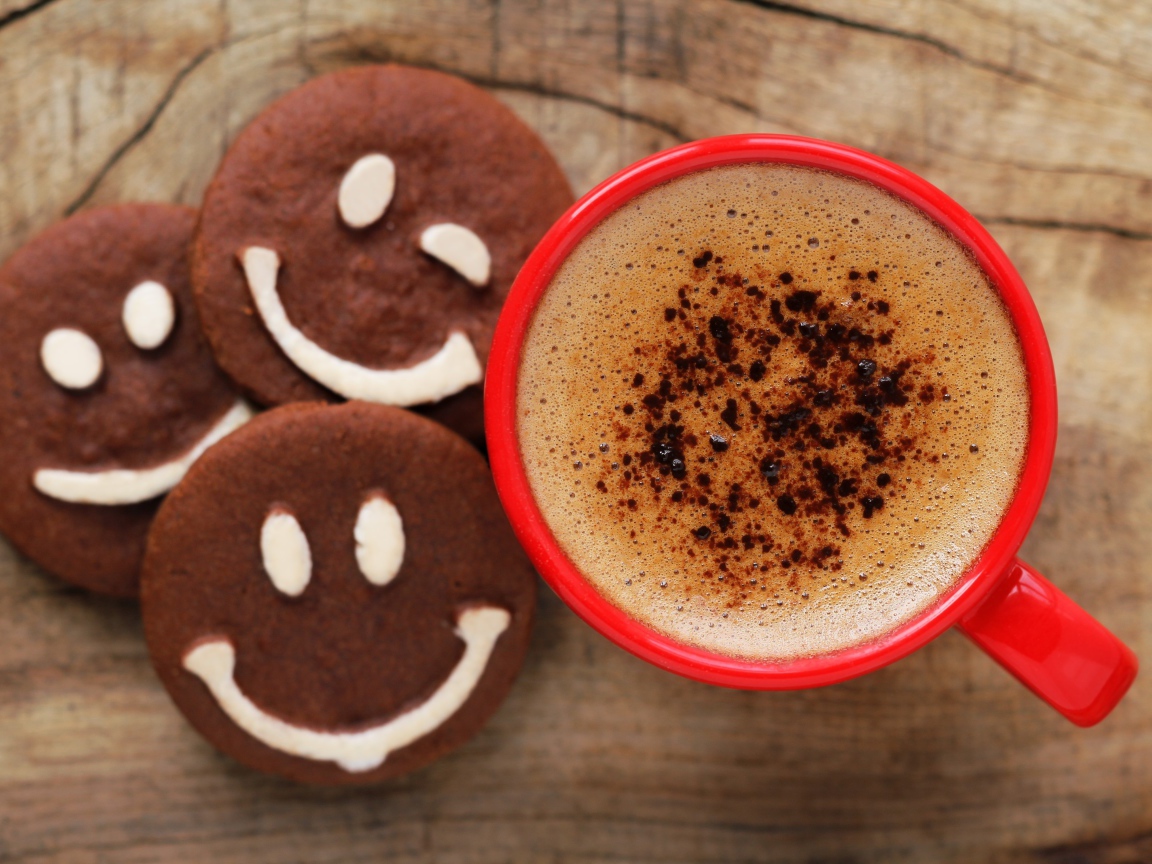 Шоколадное печенье смайлы на столе с чашкой кофе