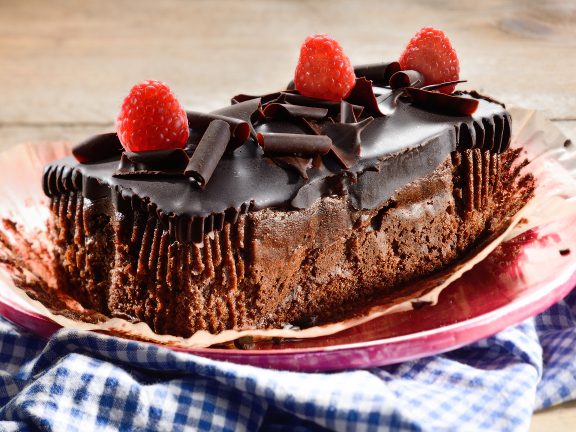 Шоколадное пирожное со свежей малиной на тарелке