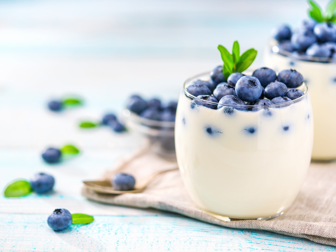 Десерт с йогуртом и ягодами черники с стеклянных стаканах