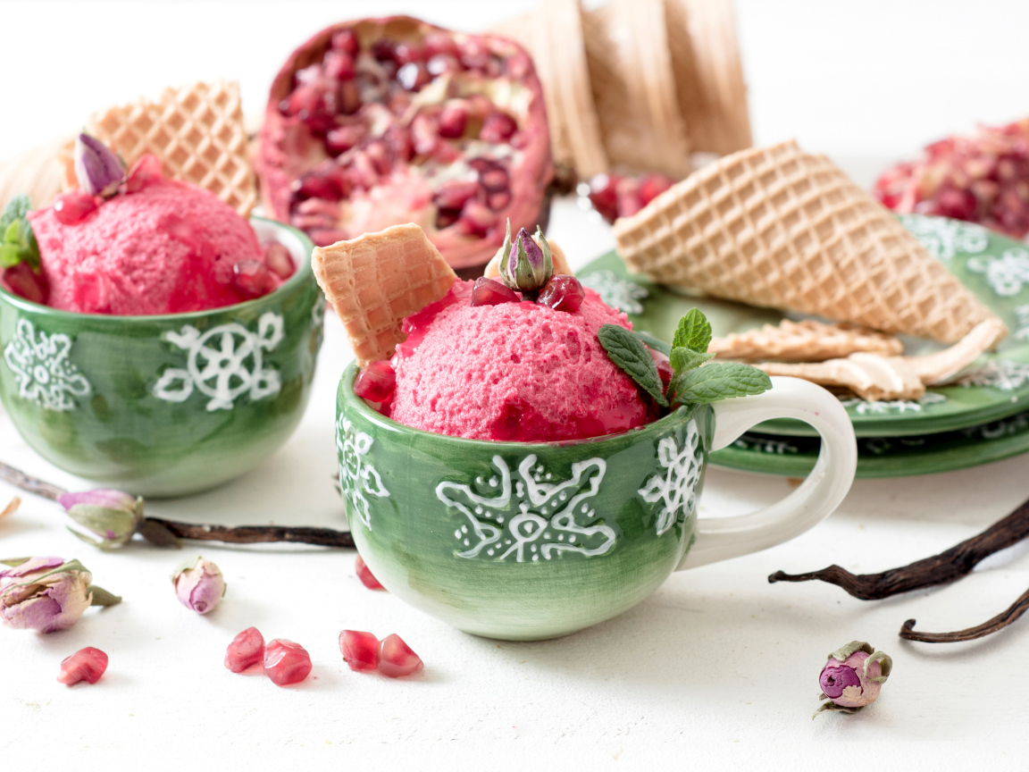 Мороженое с зернами граната в зеленых чашках на столе