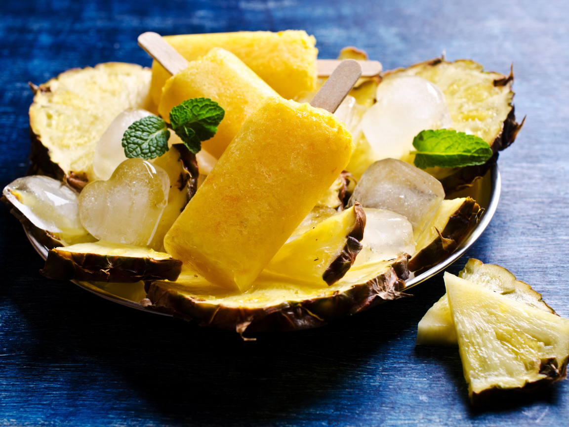 Ананасовое мороженое со льдом лежит на кусочках свежего ананаса