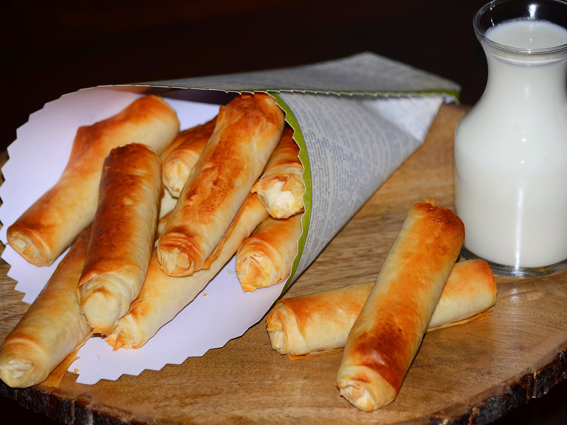 Сладкая выпечка с творогом на столе с кувшином молока