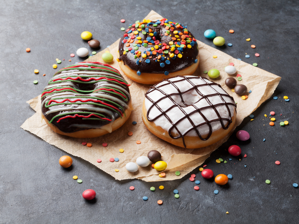 Три аппетитных сладких пончика с конфетами 