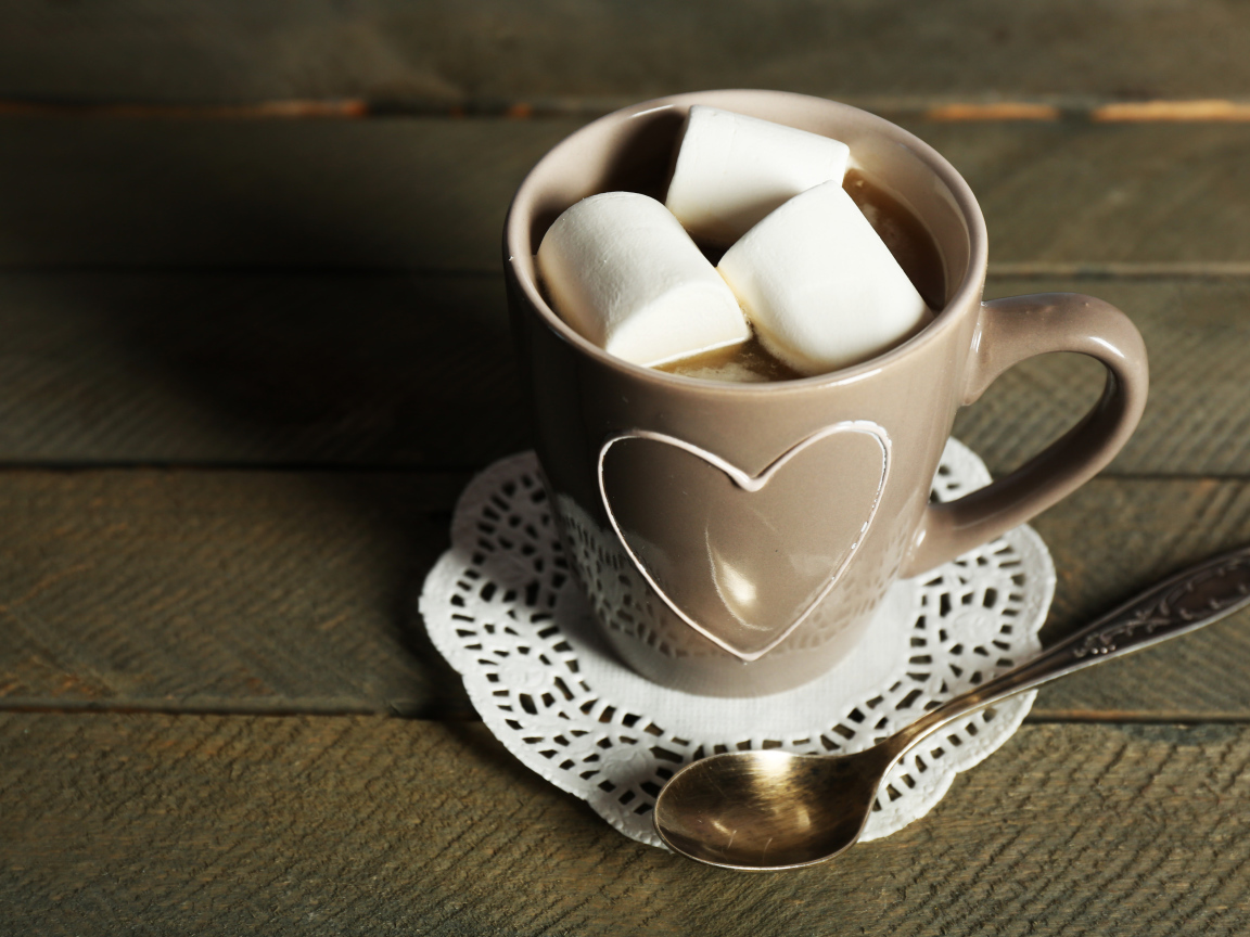 Чашка какао с кусочками маршмеллоу на кружевной салфетке