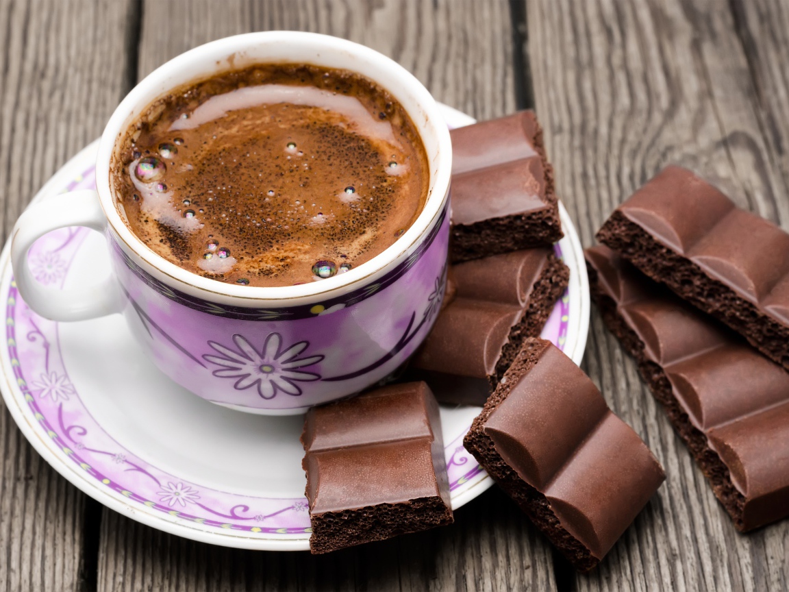 Чашка кофе с черным пористым шоколадом 