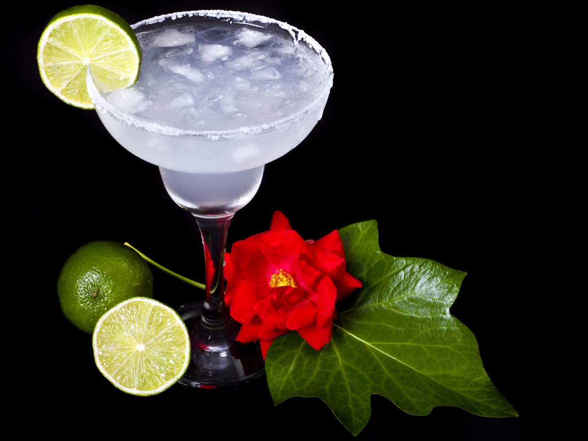 Бокал коктейля со льдом и лаймом на черном фоне