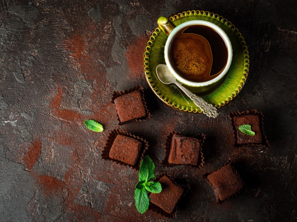 Ароматный кофе в чашке с шоколадными конфетами 