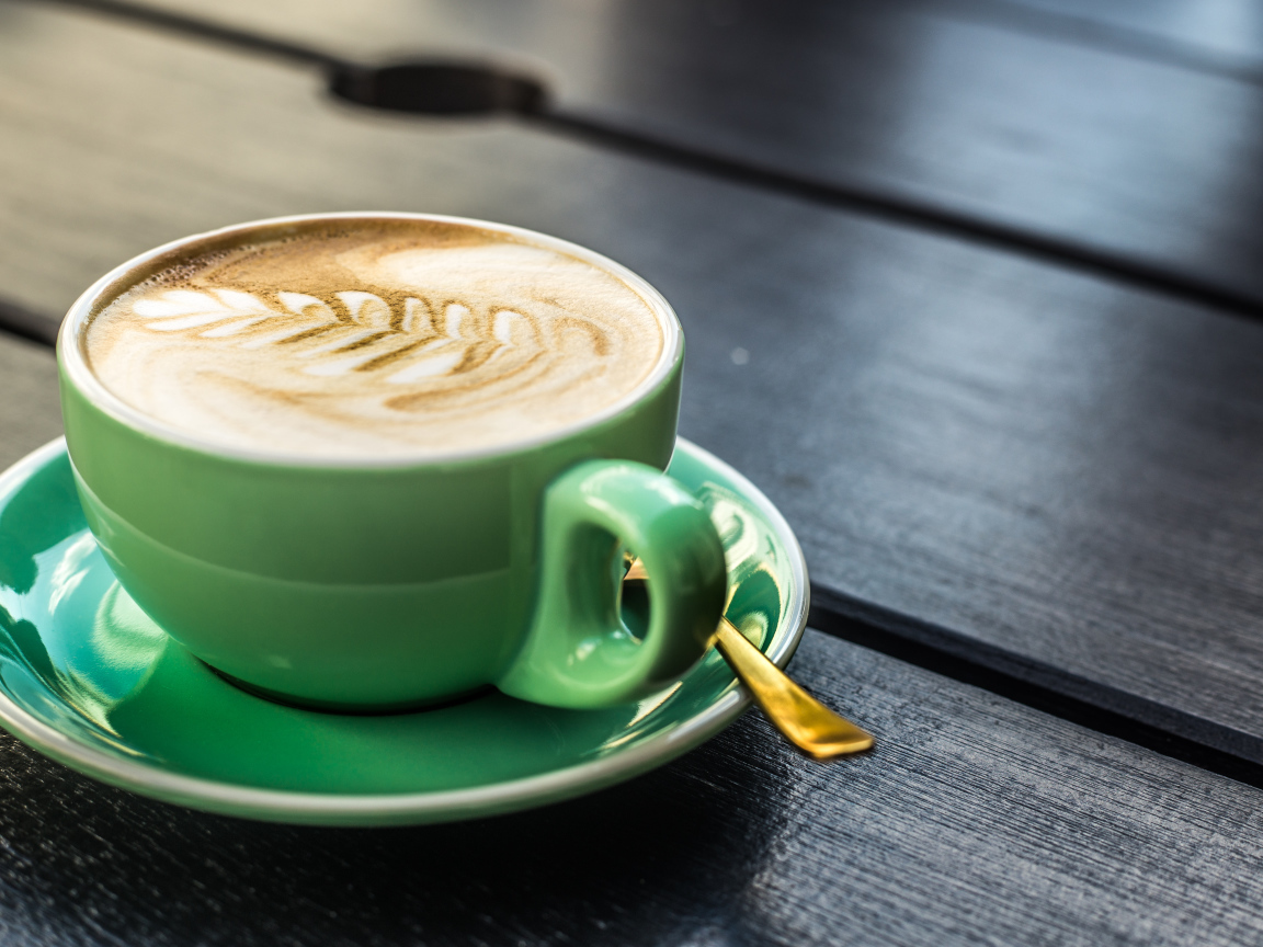 Зеленая чашка капучино с белой пенкой 
