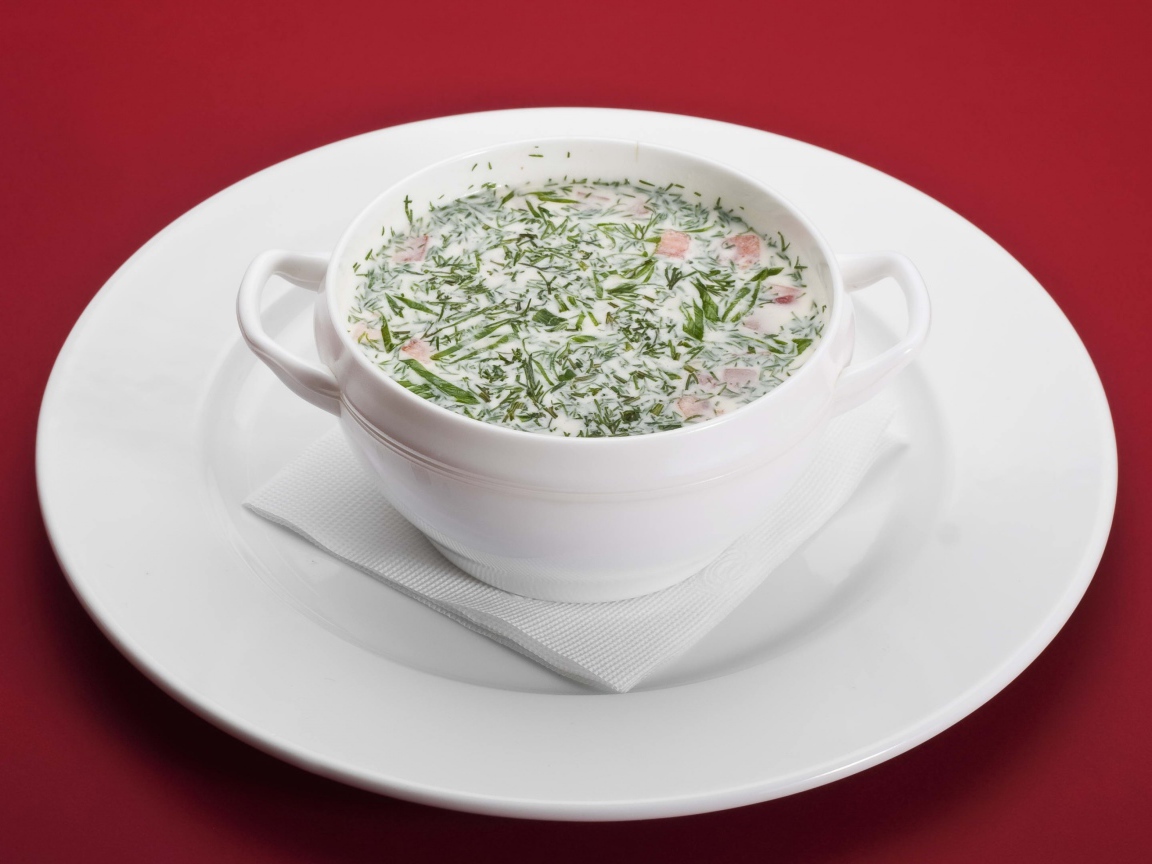 Окрошка в белой пиале на белой тарелке