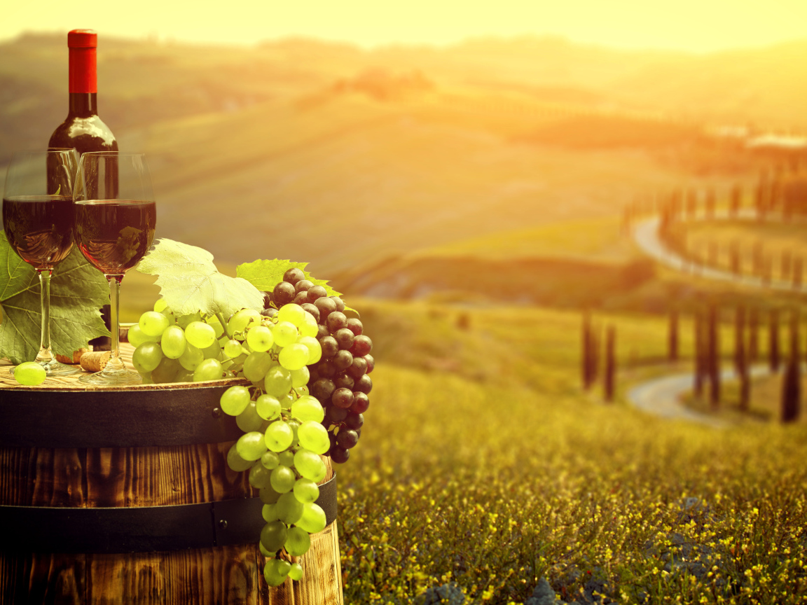 Два бокала с красным вином и свежий виноград на бочке 