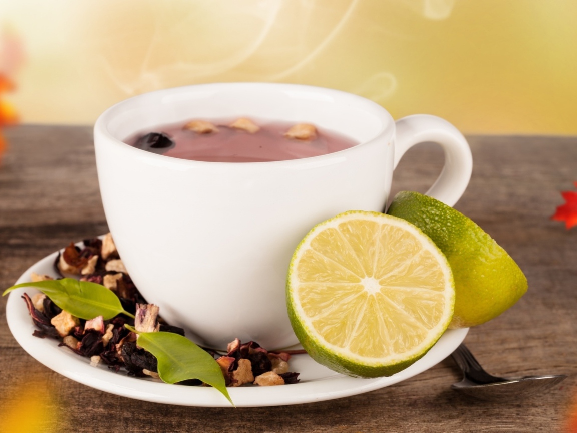 Белая чашка чая с кусочками лайма на белом блюдце