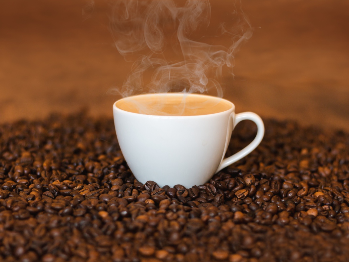Белая чашка с кофе на кофейных зернах