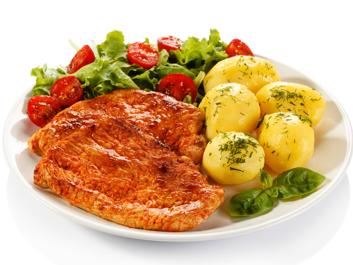 Аппетитные отбивные с вареным картофелем и салатом на белой тарелке