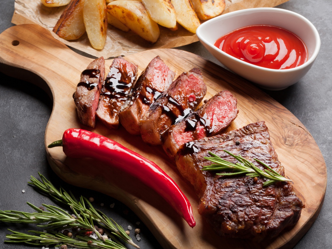 Аппетитный сочный стейк с соусом, красным перцем и специями на столе