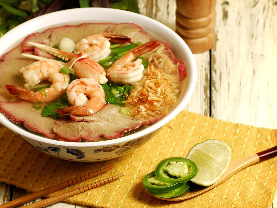 Тарелка супа с креветками и морепродуктами на столе