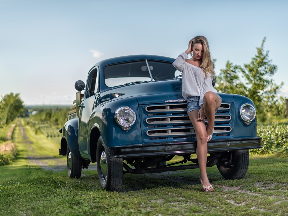 Молодая девушка стоит рядом с зеленым автомобилем Studebaker Pickup, 1953 года