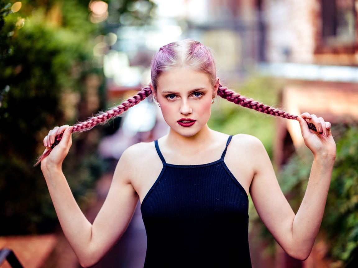 Молодая девушка с розовыми косами на голове