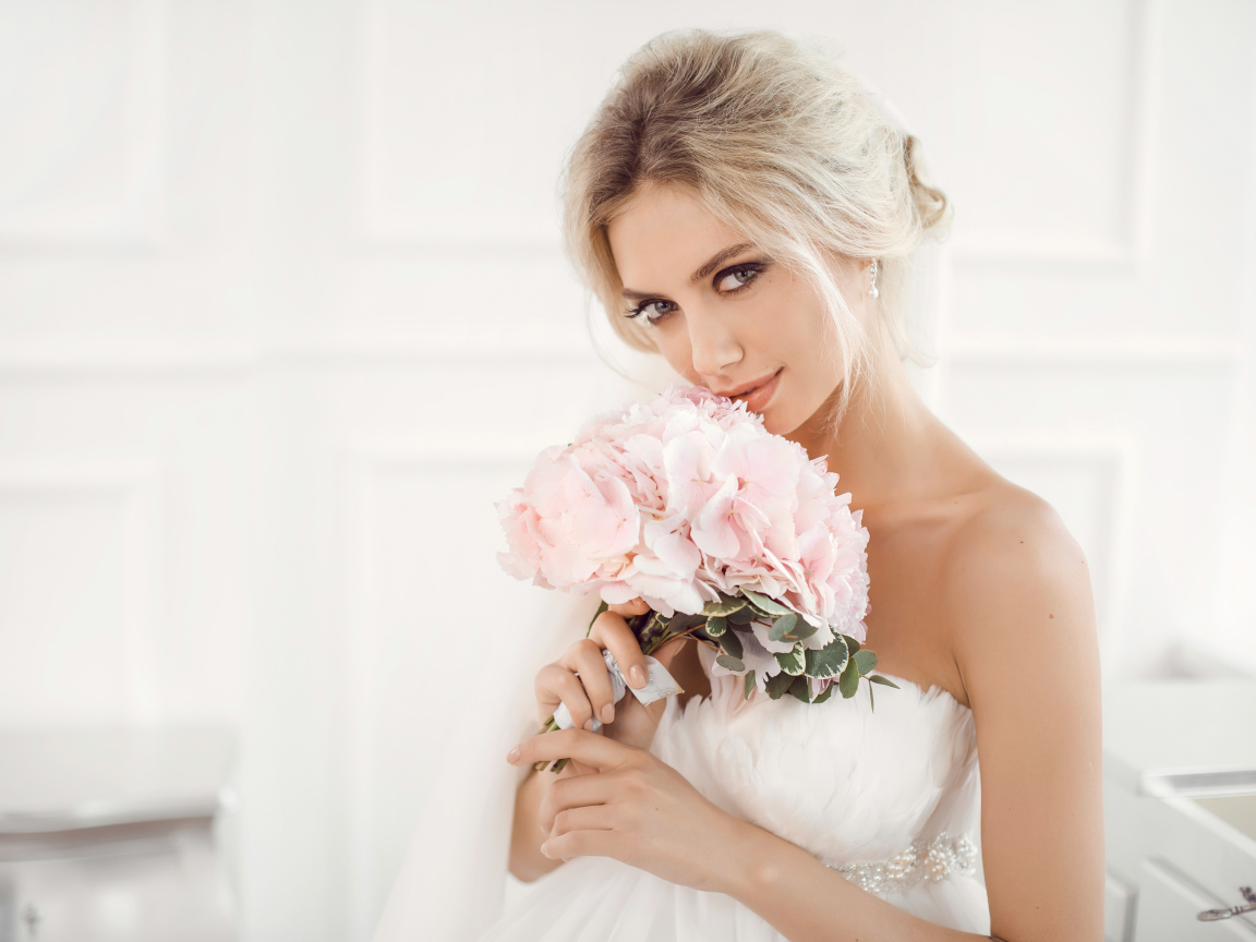 Красивая блондинка невеста с букетом розовых цветов в руках
