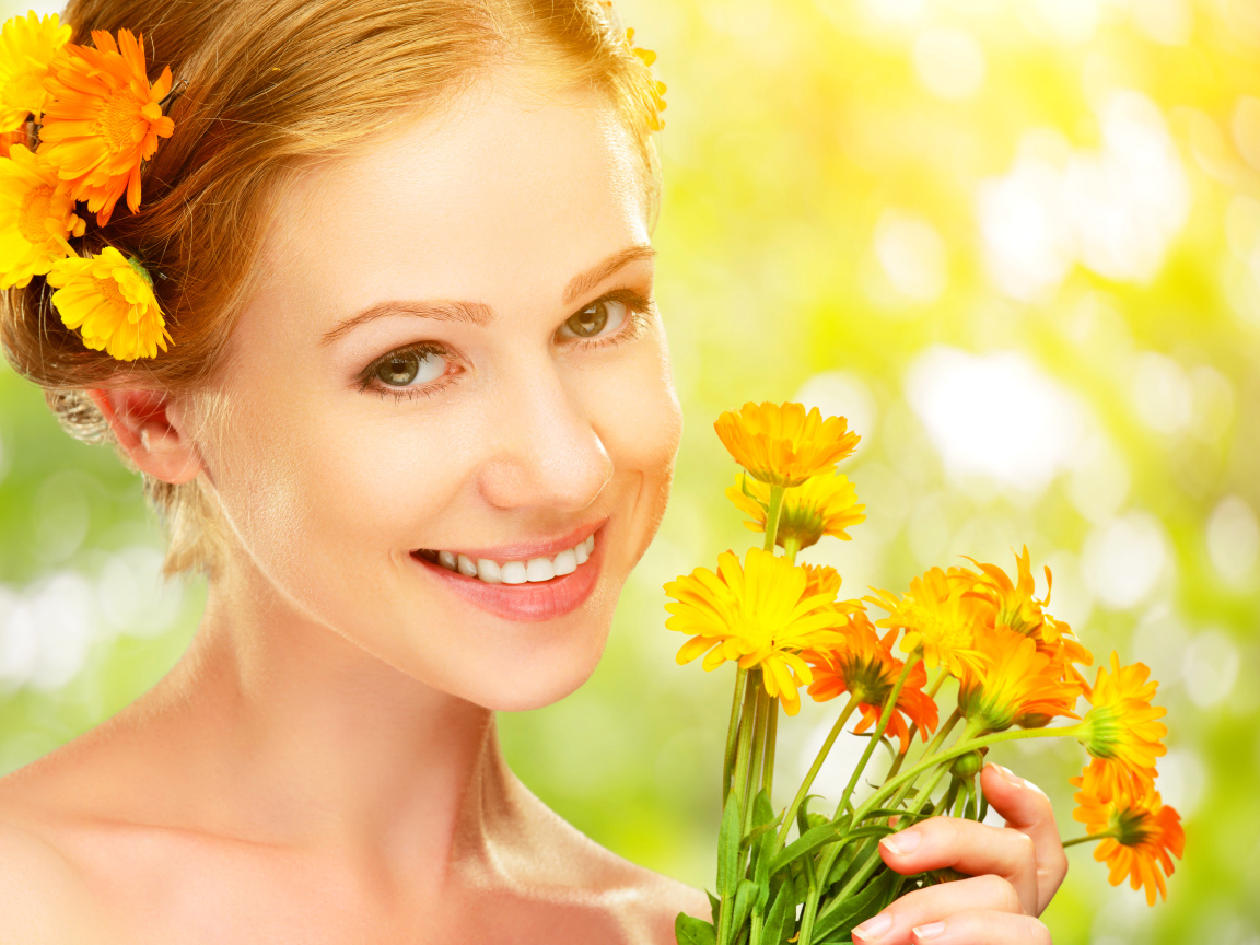 Красивая улыбающаяся девушка с цветами календулы в волосах