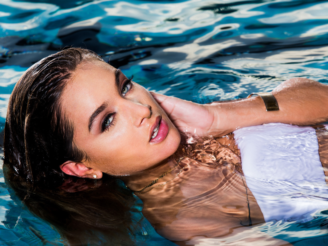 Красивая молодая девушка купается в чистой воде