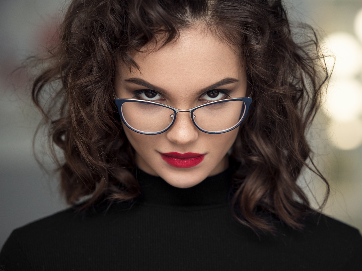 Брюнетка с красными губами с очками на лице
