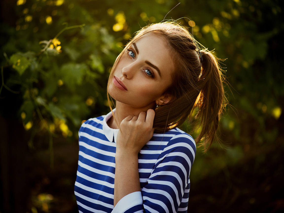 Молодая голубоглазая девушка в полосатом платье
