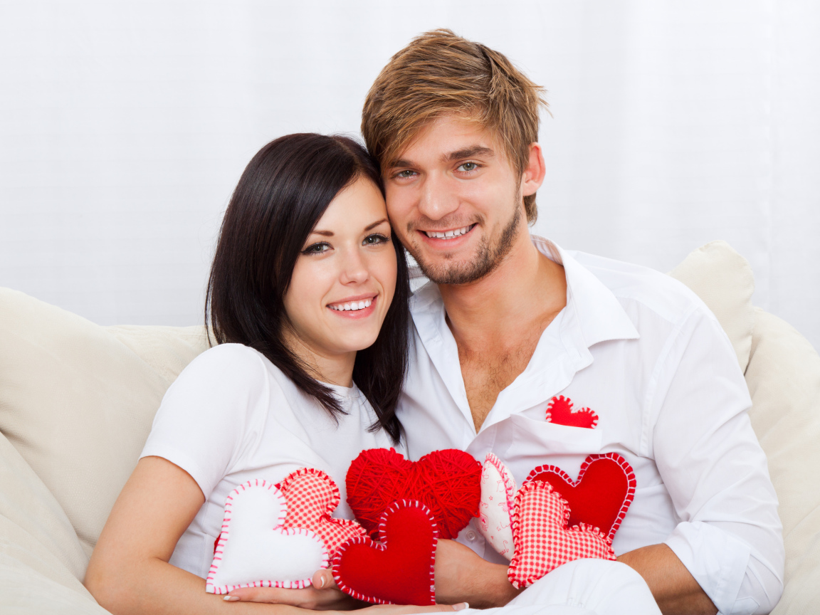 Красивая влюбленная пара с маленькими сердечками в руках