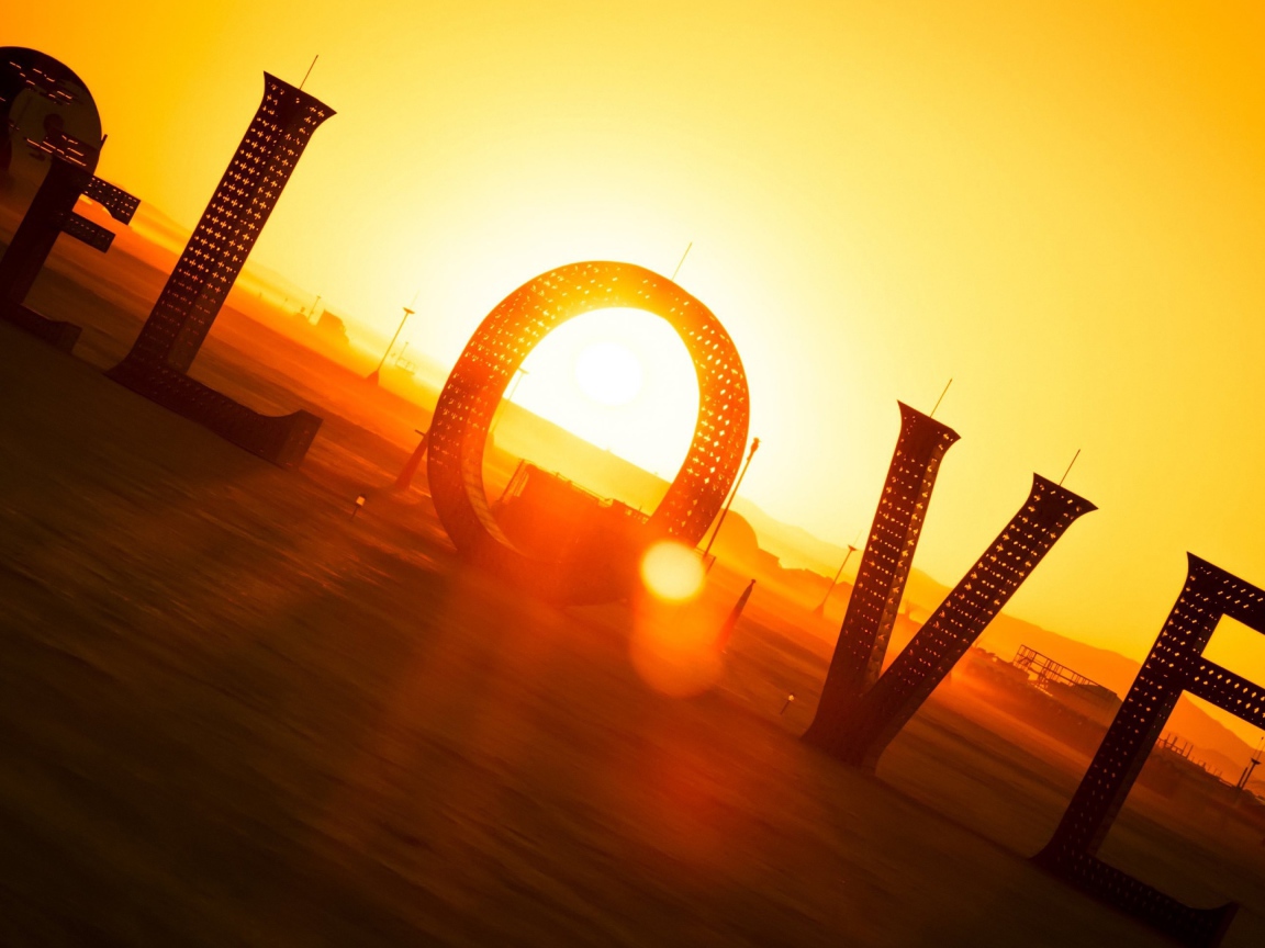 Большая надпись Любовь в лучах солнца на закате