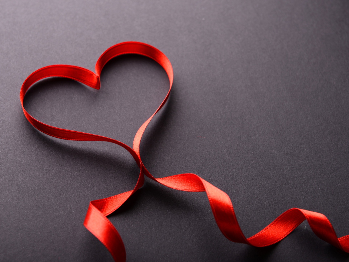 Красное сердце из атласной ленты на сером фоне