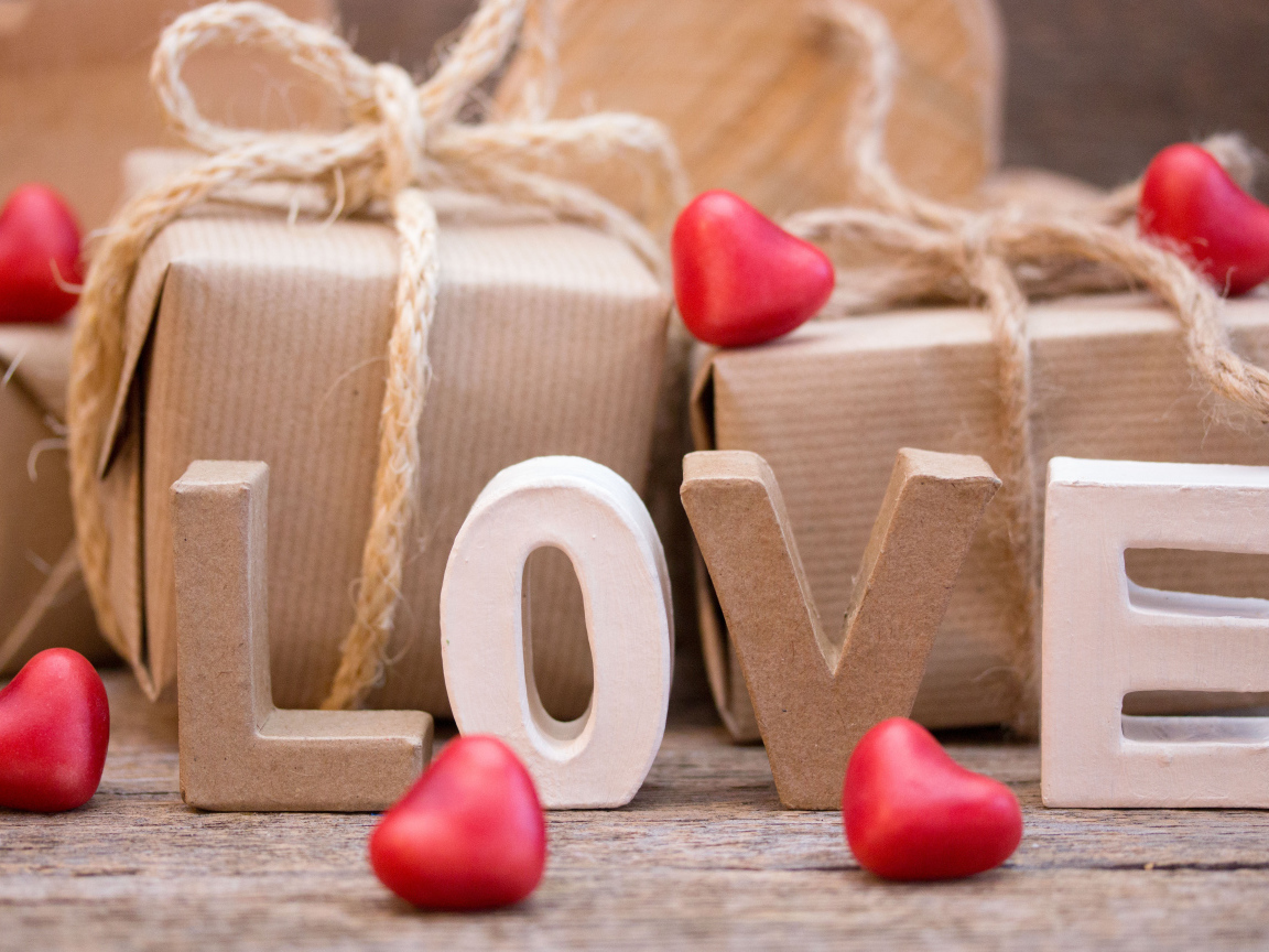 Романтические подарки и надпись Love с красными сердечками