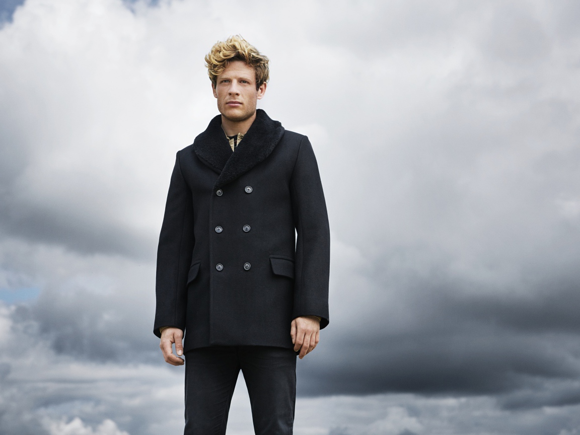 Актер Джеймс Нортон в черном пальто на фоне неба