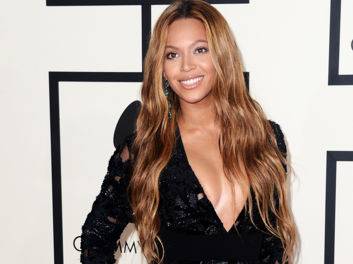 Красивая улыбающаяся певица Бейонсе в черном платье