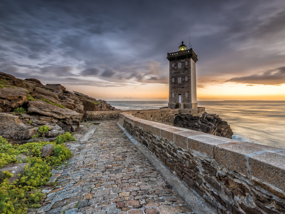 Маяк на берегу океана под красивым небом