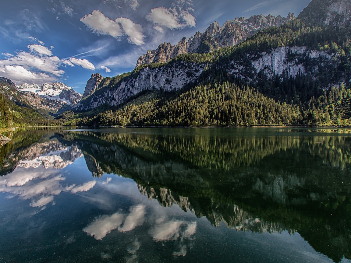 Сосны и горы отражаются в озере  