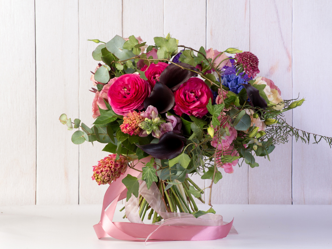 Праздничный букет с розовыми лентами на столе