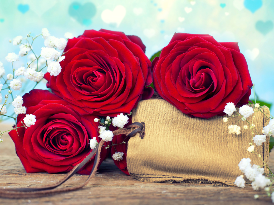 Три больших красных розы с тканевым мешочком