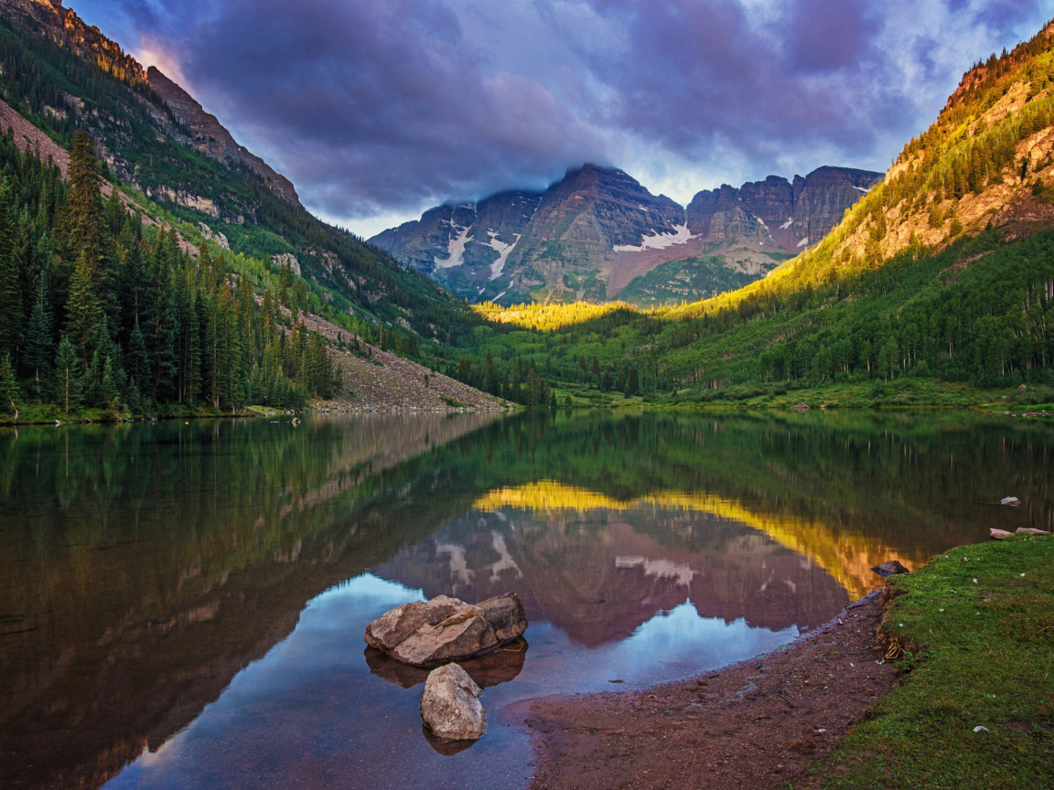 Покрытые зеленью горы отражаются в чистой воде озера