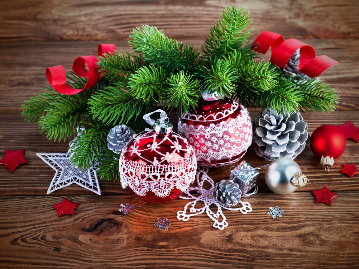 Красивые елочные игрушки с зеленой еловой веткой на деревянном столе 