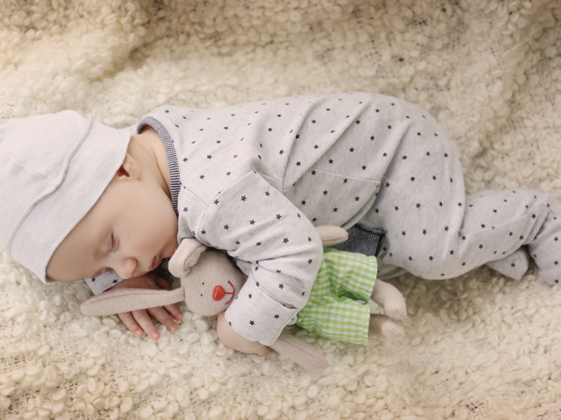 Грудной ребенок спит с любимой мягкой игрушкой