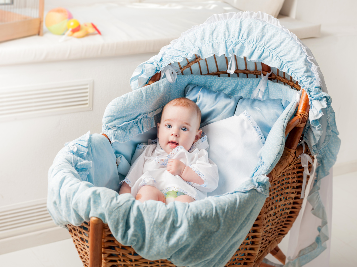 Маленький голубоглазый младенец в кроватке