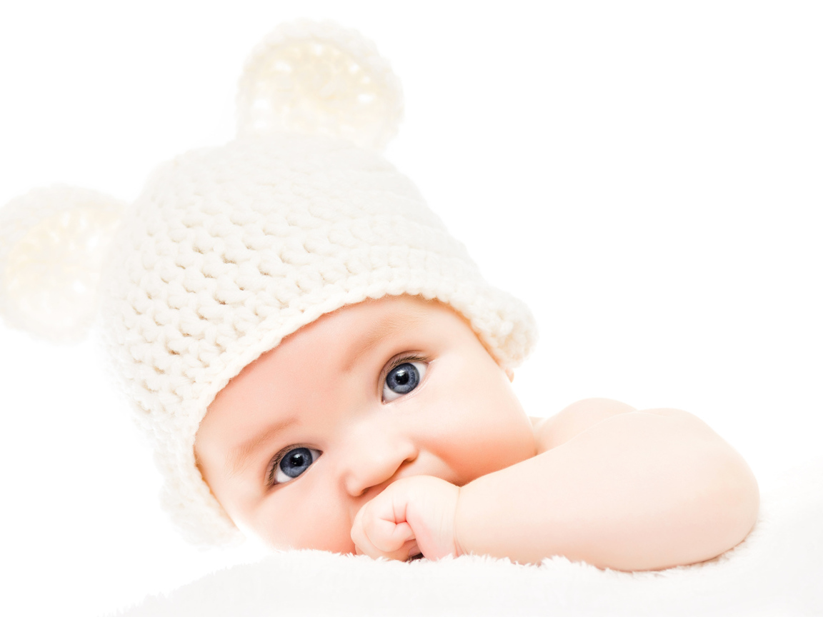Голубоглазый младенец с белой шапке с ушками на белом фоне